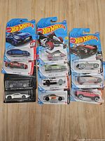 Full view of all blister-carded Hot Wheels in two columns on wooden surface