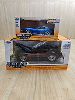 Front view of both boxed model cars showing vehicles and packaging fronts