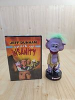 Front view of DVD case and Peanut bobblehead