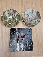 Front view of two plates and glass tray displaying artwork and shapes