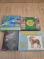 Top view of four boxed items: Pattern Painter kit, Kite Kids puzzle, Personally Incorrect game, Donkey Party Game