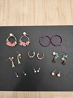 Overview of all seven earring pairs on black background