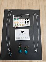Group shot of both necklaces, Impulse! earring card, Cleo earring card and teal dangle earrings