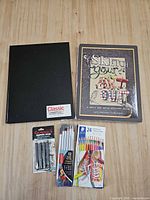 Full view of sketchbook, art book, coloured pencils, sketch pencils, graphite sticks
