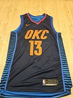 Full front view of the navy OKC #13 Nike Swingman jersey laid flat