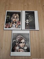 All three framed portrait prints laid out on wood surface