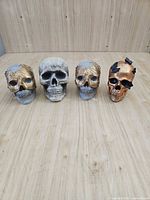 Front view of all four skull figurines lined up