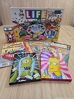 Front view of board game box, Duff can, comics and DVDs
