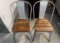 front view of both metal chairs with wood seats