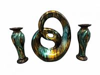 Front view of abstract loop statue and two matching candleholders