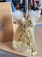 Front view of angel tree topper beside original Avon Gift Collection box