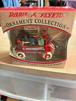 Front view of Radio Flyer Ornament Collection box showing red wagon ornament inside