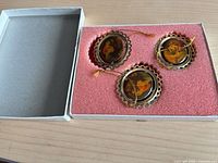 Open box showing three ornaments in foam insert