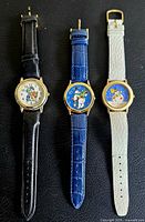 Front view of three watches showing dials and straps