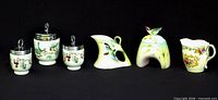 All six porcelain pieces lined up against black background