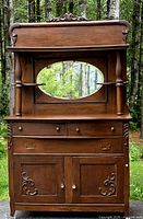 Front view of full sideboard showing upper shelf, mirror, drawers, doors and carvings
