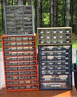 Four organizer cabinets displayed outdoors on a table showing drawers and contents