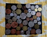 All coins laid out on black board showing obverses and reverses