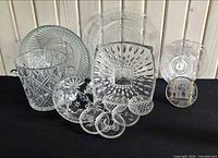 Full grouping of clear glass and crystal pieces arranged on black surface