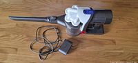 Vacuum with crevice tool and charger cord laid out