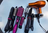All seven hair styling tools laid out on white surface