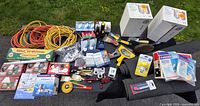 Wide view of entire lot showing carpets, extension cords, boxed fixtures and packaged supplies