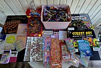 Overhead view showing full assortment including chess set, gumball machine, marker bin, art kits, sticker sheets and calculators