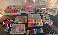 Overview of entire lot on table showing organizers, looms, cords, beads