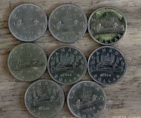 All eight Voyageur dollar coins arranged showing reverse designs and years