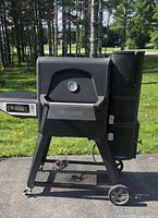 Full left-side view of Masterbuilt Gravity Series grill/smoker on cart