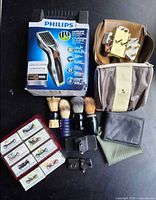 Full lot view showing clipper box, brushes, toiletry bags, miniature car set, adapters, wallet and cloth