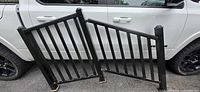 Both stair railing panels and end posts leaned against vehicle for size comparison