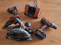 All five RIDGID 18V cordless tools laid out: circular saw, drill, impact driver, charger, battery attached to drill