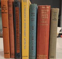 Spine view of all seven hardcover books standing upright
