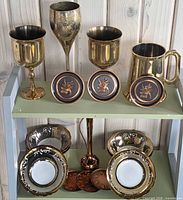 Full lot on two-tier shelf displaying goblets, coasters, pitcher, bowls, saucers, bud vase