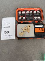 All four heart earrings on scale displaying 5.00 g with reference note