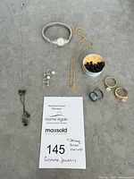 Overall layout of all jewelry pieces including watch, necklaces, earrings, rings, bead tin