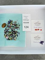 Overview of tray with all gemstones, tiger’s eye cabochon, ID card and separate labelled cards