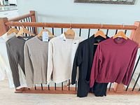 Full view of all six tops hanging on rail