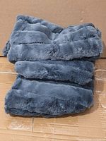 Stack of three blue faux fur pillow covers