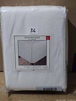 Front of packaged white king solid bed skirt