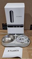 Front view of Xtuoes feeder with bowls, cable, manual
