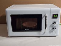 Front view showing entire microwave exterior, handle, window, control panel