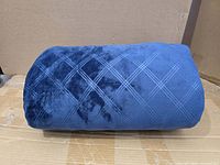 Rolled navy weighted blanket showing diamond quilt pattern