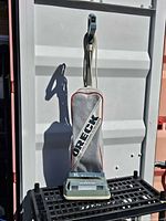 Full view of Oreck Commercial XL upright vacuum standing upright on a grate