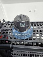 Front angled view of RainMate showing blue basin and black motor housing on slotted shelf