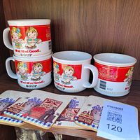 Front view of four Campbell's mugs stacked beside four coasters