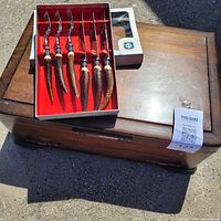 Wooden chest with faux antler cutlery box resting on lid