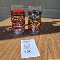 Both Coca-Cola promotional glasses side by side on table