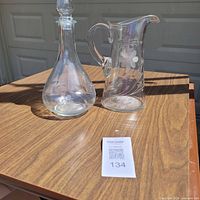 decanter and pitcher side by side on table